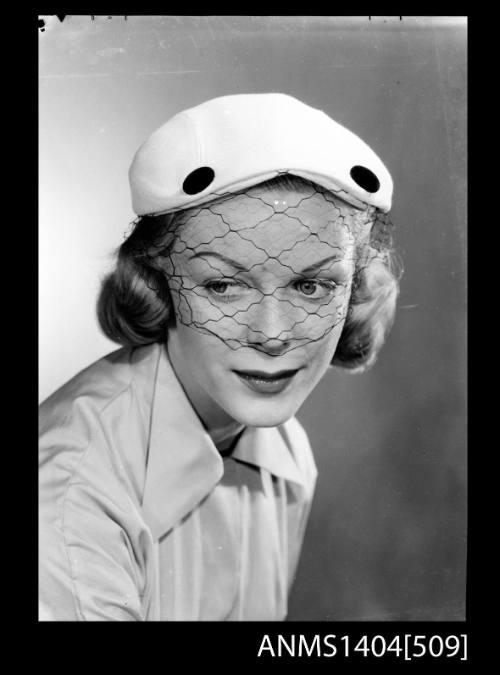 Photographic negative of a model posing with a hat