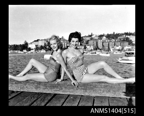 Photographic negative of two swimsuit models posing on a wharf