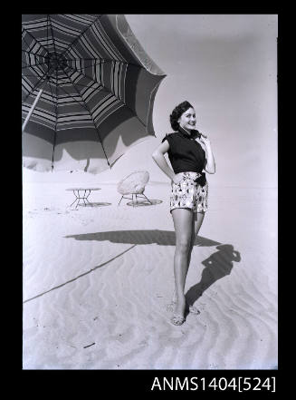 Photographic negative of a model posing in casual wear on a beach