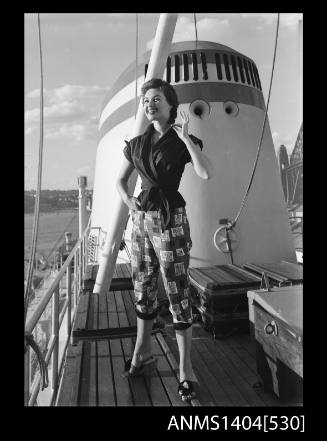 Photographic negative of a model posing in a shirt and pants on a ship