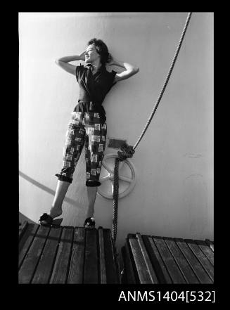 Photographic negative of a model posing in a shirt and pants on a ship