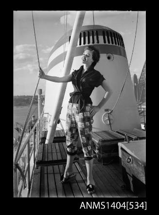 Photographic negative of a model posing in a shirt and pants on a ship