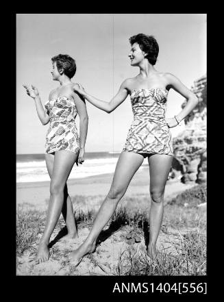 Photographic negative of two swimsuit models posing on a beach
