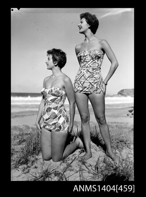 Photographic negative of two swimsuit models posing on a beach