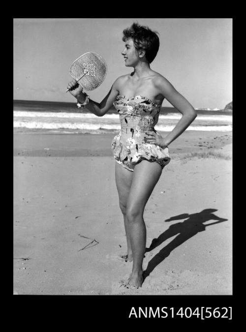 Photographic negative of a swimsuit model posing on a beach