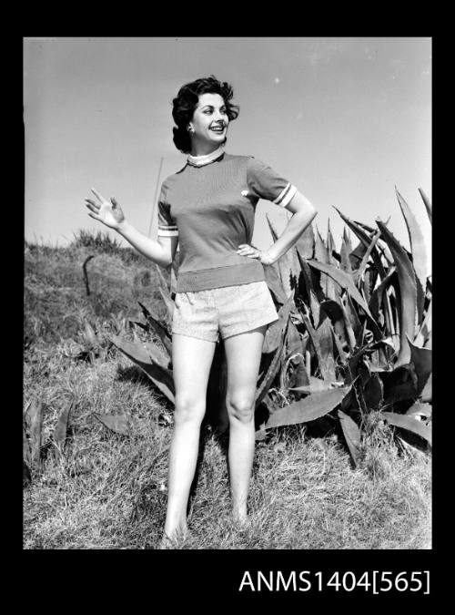 Photographic negative of a model wearing a t-shirt and shorts in front of an aloe vera plant