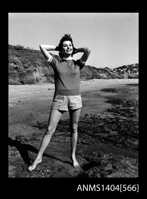 Photographic negative of a model wearinf a t-shirt and shorts on a beach