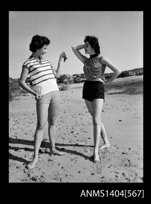 Photographic negative of a two models in casual wear on a beach