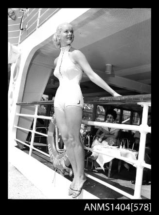 Photographic negative of a swimsuit model posing on a ship