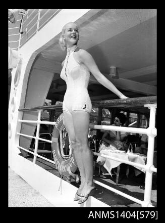 Photographic negative of a swimsuit model posing on a ship