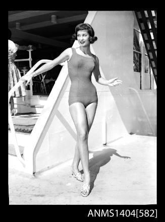 Photographic negative of a swimsuit model posing on a ship