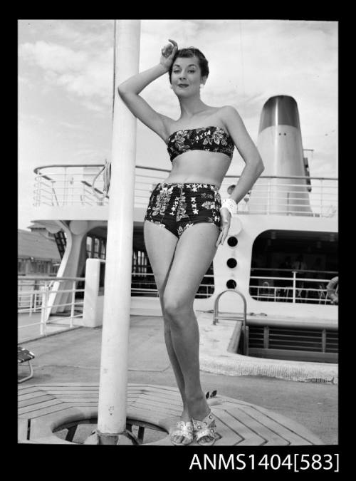 Photographic negative of a swimsuit model posing in a bikini on a ship