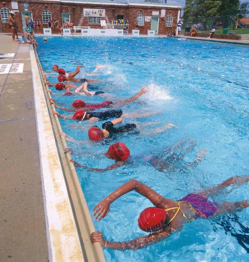 Children learning to swim kicking off the side, Enfield Swimming Centre