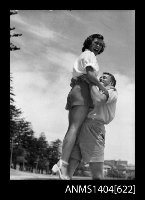 Photographic negative of a man and woman modelling casual wear at a beach