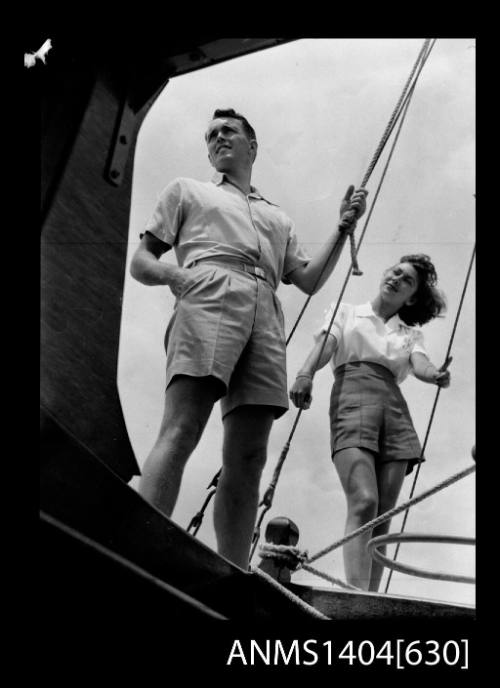 Photographic negative of a man and woman modelling casual wear on a boat