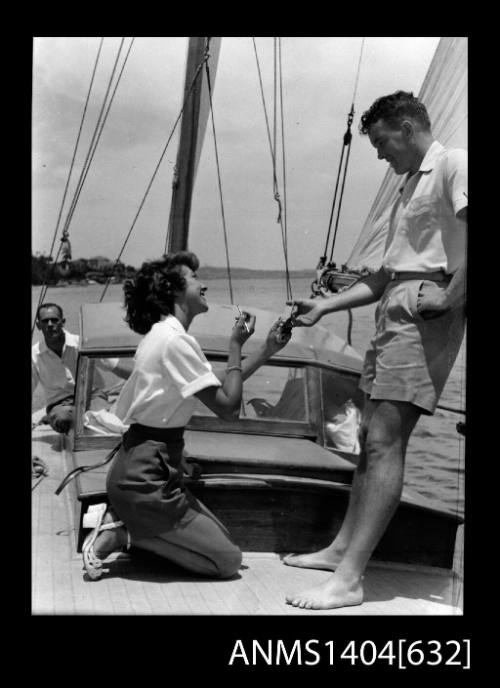 Photographic negative of a man and woman modelling casual wear on a boat