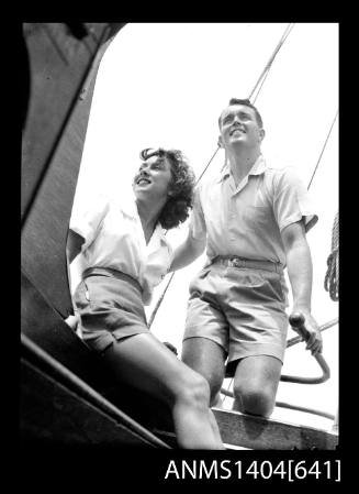 Photographic negative of a man and woman modelling casual wear on a boat