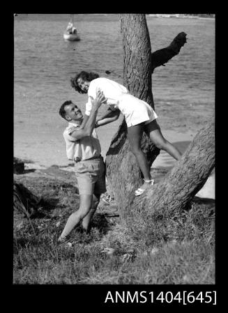 Photographic negative of a man and woman modelling casual wear on a beach