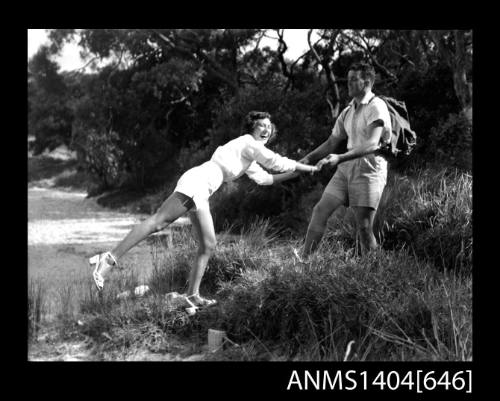 Photographic negative of a man and woman modelling casual wear on a beach