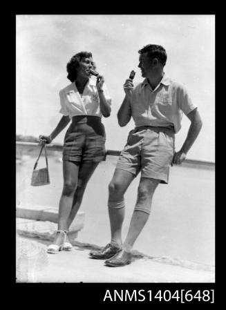 Photographic negative of a man and woman modelling casual wear on a beach