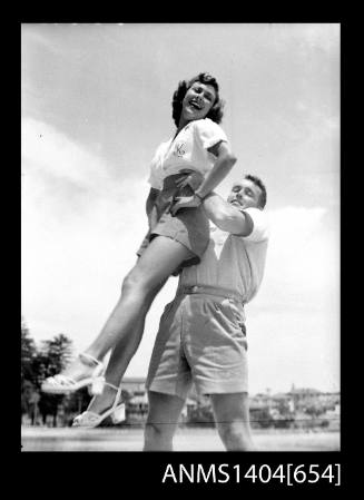 Photographic negative of a man and woman modelling casual wear on a beach