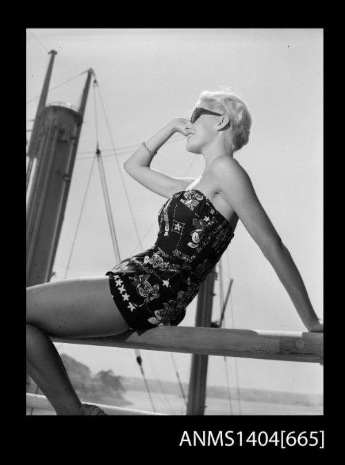 Photographic negative of a swimsuit model posing on a ship