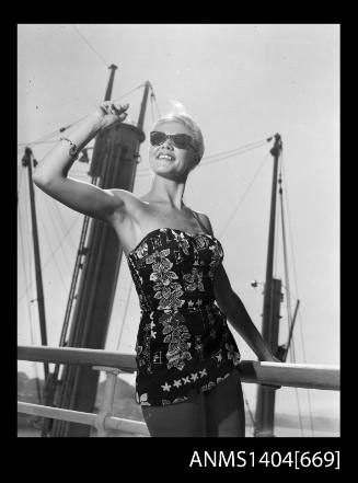 Photographic negative of a swimsuit model posing on a ship