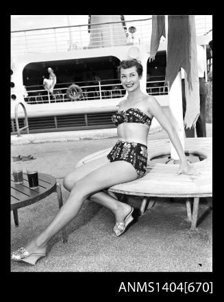 Photographic negative of a swimsuit model posing on a ship