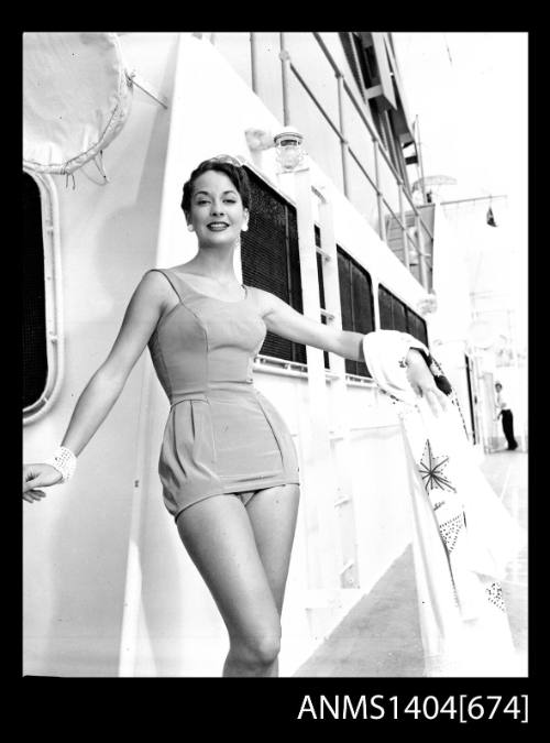 Photographic negative of a swimsuit model posing on a ship