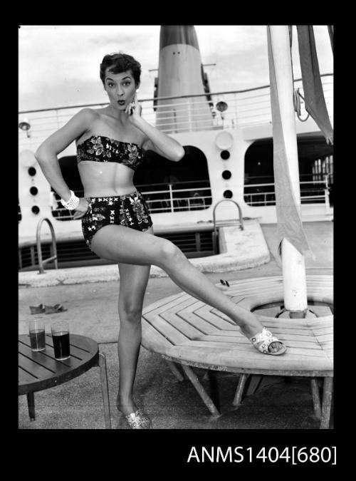 Photographic negative of a swimsuit model posing on a ship