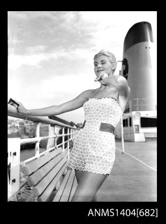 Photographic negative of a swimsuit model posing on a ship