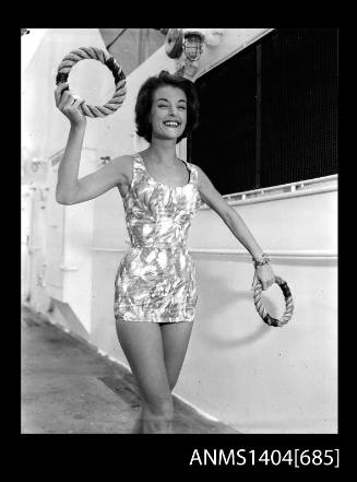 Photographic negative of a swimsuit model posing on a ship with quoits