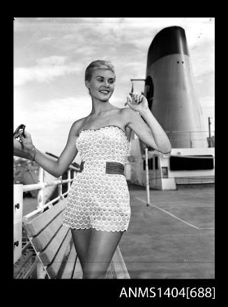 Photographic negative of a swimsuit model posing on a ship