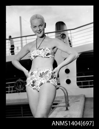 Photographic negative of a swimsuit model posing on a ship