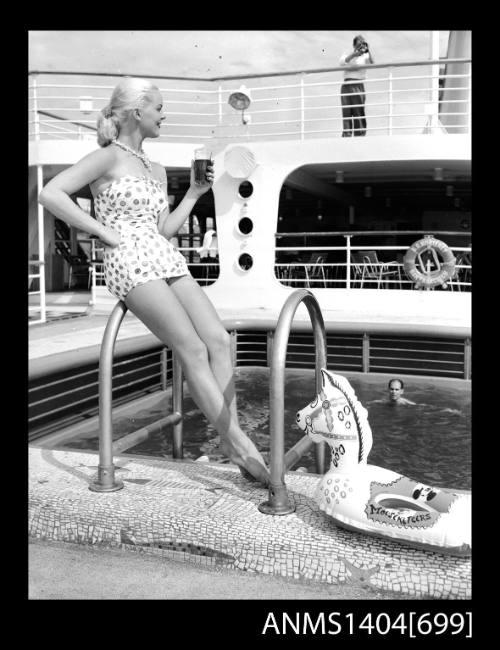 Photographic negative of a swimsuit model posing by a pool on a ship