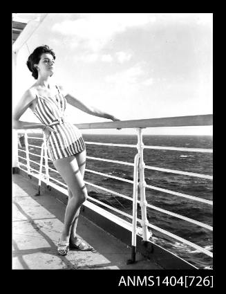 Photographic negative of a swimwear model posing on a ship