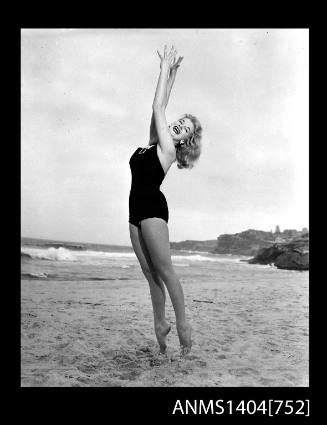 Photographic negative of a swimsuit model posing on a sand dune