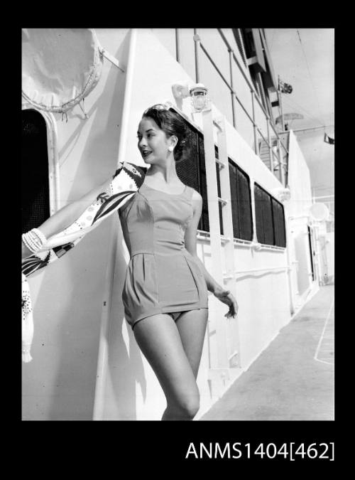 Photographic negative of a swimsuit model posing on a ship