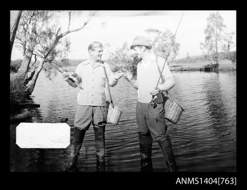 Photographic negative of two men fishing in a river