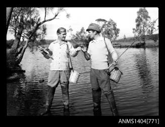 Photographic negative of two men fishing in a river