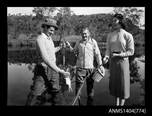 Photographic negative of two men and a woman fishing in a river