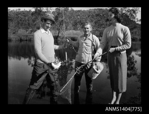 Photographic negative of two men and a woman fishing in a river