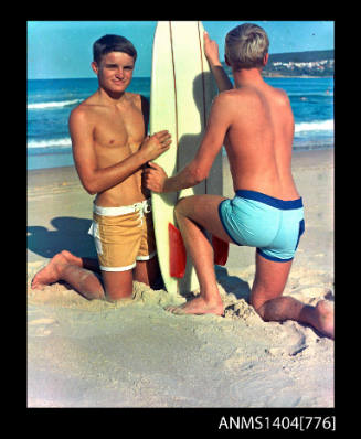 Photographic transparency of two teengage buys in swimwear at the beach with a surfboard