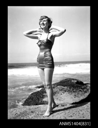 Photographic negative of a swimsuit model posing on a beach