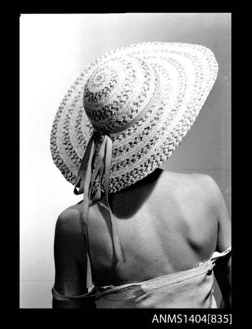 Photographic negative of a model posing with a hat