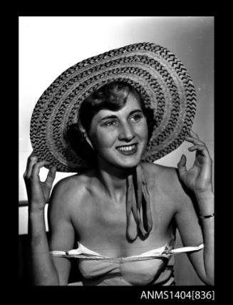 Photographic negative of a model posing with a hat