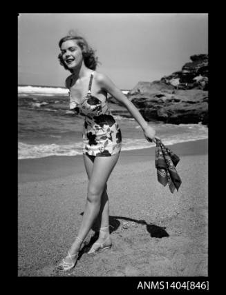 Photographic negative of a swimsuit model posing on a beach