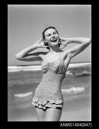 Photographic negative of a swimsuit model posing on a beach