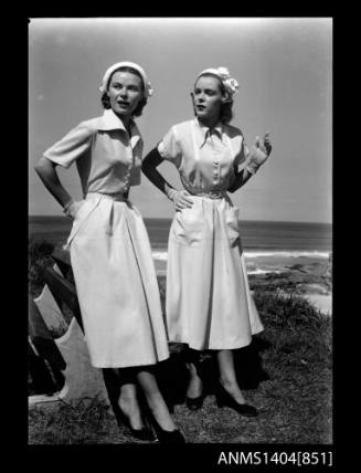 Photographic negative of two models posing near a beach