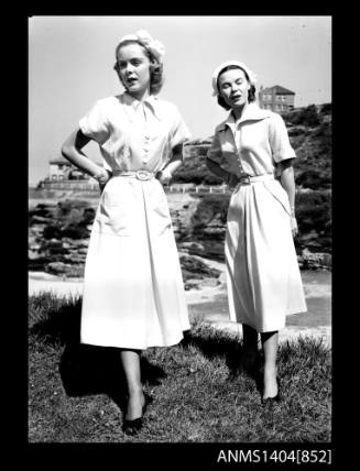 Photographic negative of two models posing near a beach